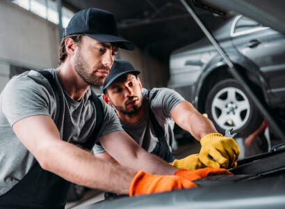 Techniciens effectuant une intervention sous le capot d’une voiture
